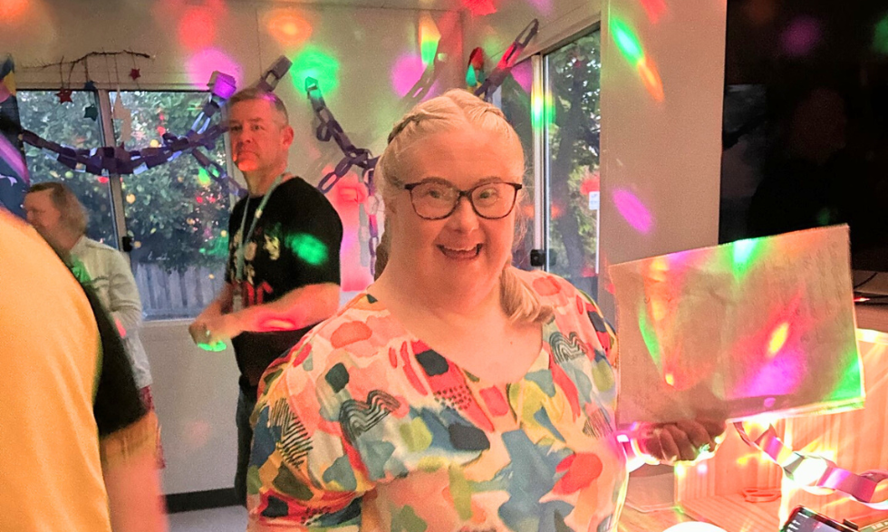 A Happy client sitting in the colourful neon disco space