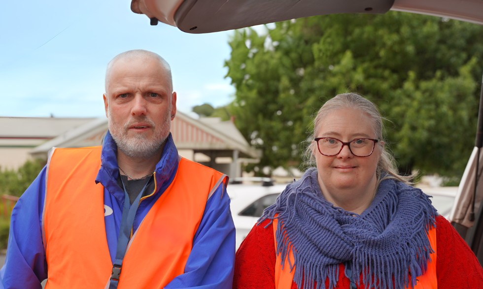 IMAGE: Two Yooralla Clients working for Meals on Wheels are posing for the camera in their uniforms